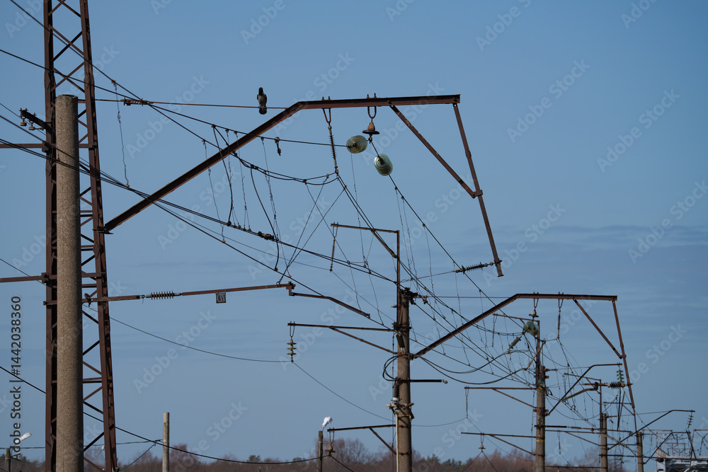 wires on a high-voltage power line next to the railway, spring day