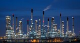 Illuminated industrial complex at night with chimneys and intricate piping structures visible clearly