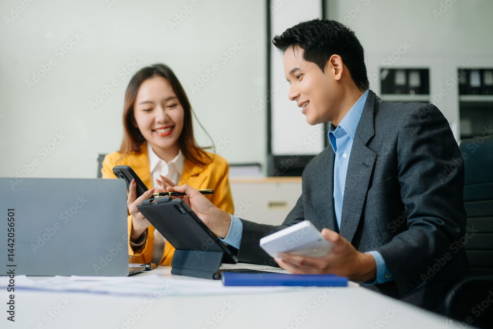 Two asian business workers talking on the smartphone and using laptop at office. Two asian business workers talking on the smartphone and using laptop at office.