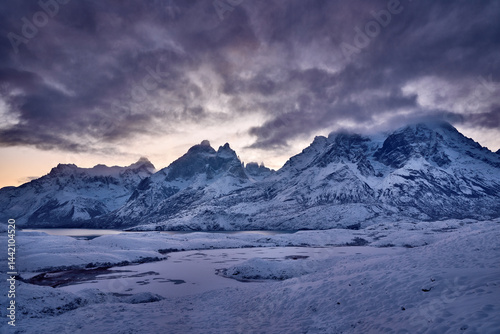 Winter twilight lanscape from Patagonia moutains with snow. Lago Nordenskjold, Torres del Paine National Park, Chile. Pink blue evening sky. Traveling in Chile,  hills in Torres del Paine NP.
