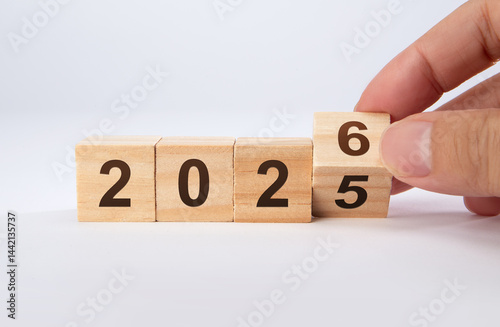 2026 Happy New Year. Wooden cube block change from 2025 to 2026 on blue. Concept 2026 New Year background.