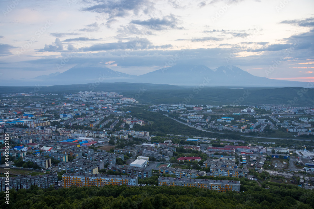 Morning cityscape. Top view of the buildings and streets of the city. Residential urban areas at twilight at dawn. Volcanoes in the distance. Petropavlovsk-Kamchatsky, Kamchatka, Far East of Russia.