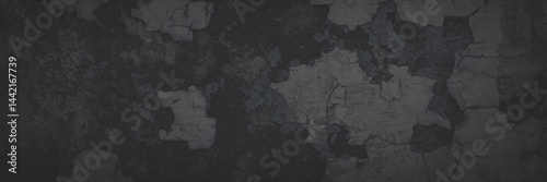 Obraz na płótnie Dark wide panoramic background. Peeling paint on a concrete wall. Faded dark texture of old cracked flaking paint. Weathered rough painted surface with patterns of cracks. Shaded background for design w salonie