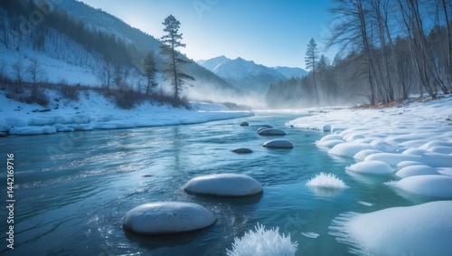 Icy patches on the river's edge amid towering mountains in the distance.