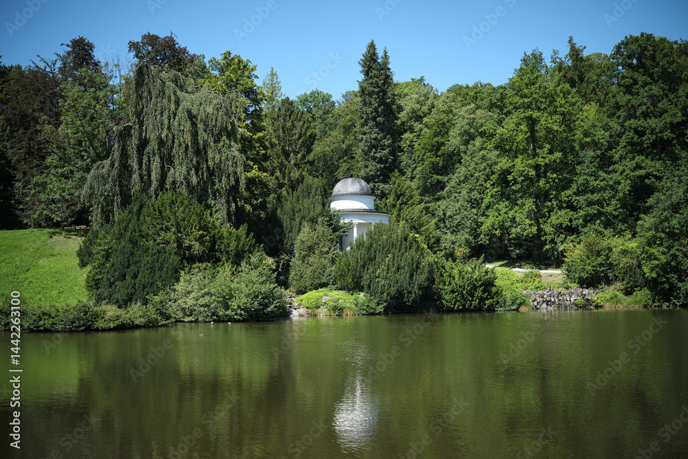This is a tranquil and picturesque park featuring a beautiful gazebo situated by a serene lake