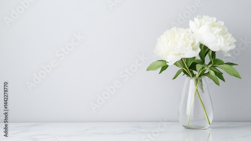 Fototapeta Naklejka Na Ścianę i Meble -  White Peonies in Glass Vase on Marble Table peonies white peonies flowers floral arrangement elegant