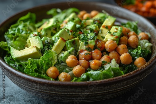 Healthy avocado chickpea salad bowl, dark background, healthy eating