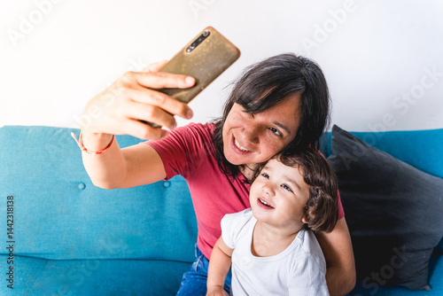 Quadro su tela Baby toddler and mother taking a selfie with a mobile phone to share on social media