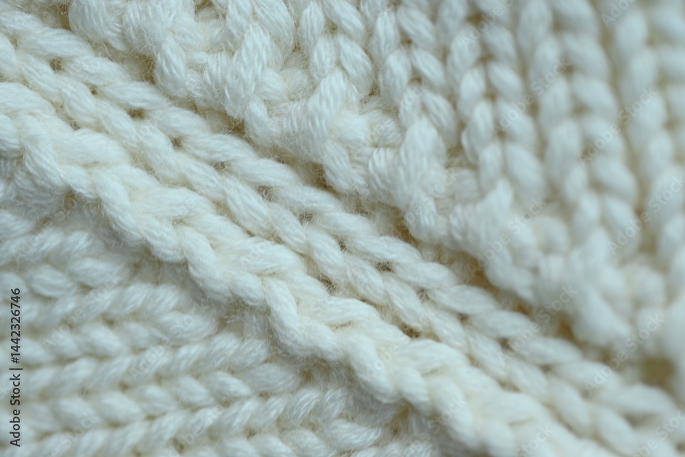 white texture of knitted wool fabric as a background, white smooth symmetrical lines of hand-knitted needlework pattern
white texture of knitted wool fabric as a background, white smooth symmetrical lines of hand-knitted needlework pattern