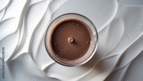 Obraz na płótnie Bird's eye view of a chocolate milk puddle in a glass against a white backdrop w salonie