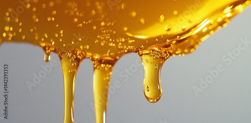 Obraz na płótnie Golden honey dripping down, close-up view showing texture and viscosity. w salonie