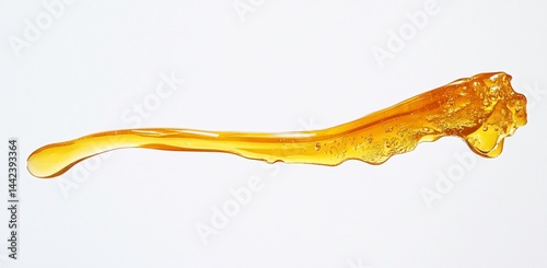 Amber liquid stream flowing on white background.