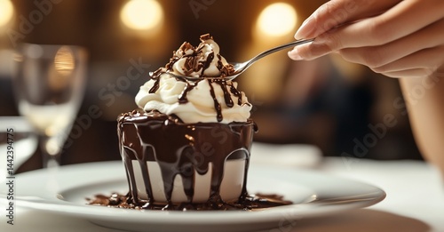 Obraz na płótnie Woman's hand scoops delicious chocolate dessert with whipped cream. w salonie