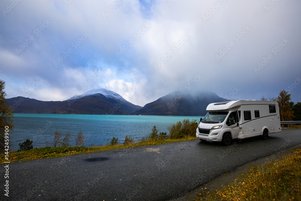 A motorhome parked by the road in the autumn landscape of the Lyngen Alps, Northern Norway, with mountains.