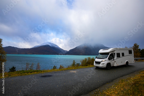 Obraz na płótnie A motorhome parked by the road in the autumn landscape of the Lyngen Alps, Northern Norway, with mountains. w salonie
