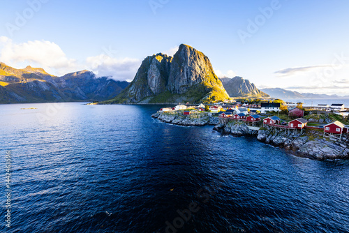Sunrise over Hamnøy, Lofoten Islands, Northern Norway, with traditional red houses and dramatic mountains along the coastline. photo