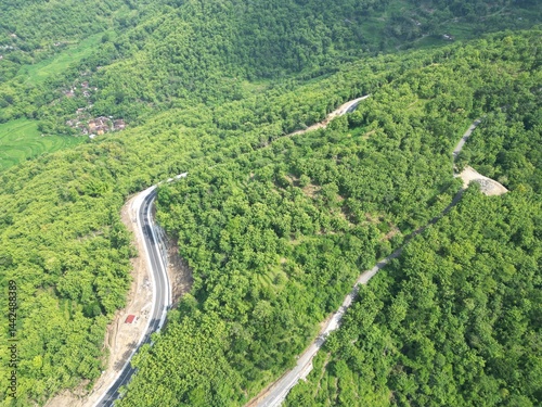 фотографія aerial view of the road that cuts through the green hills of Clongop Hill, Yogya