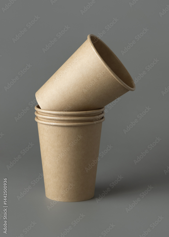 Disposable beige kraft paper cups on a gray closeup, mockup. No plastic and sustainable lifestyle