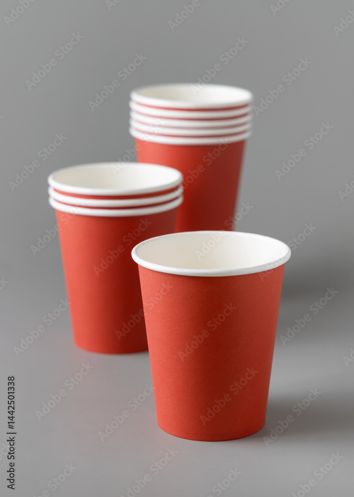 Disposable red paper cups on a gray closeup, mockup. No plastic and sustainable Christmas