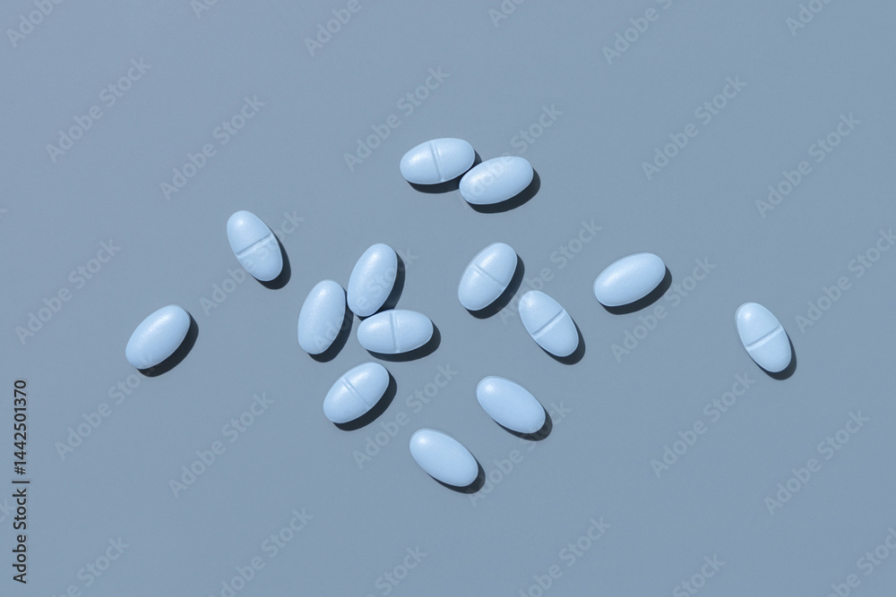 Blue medical pills on blue top view, hard light. Pharmaceutical products for healthcare