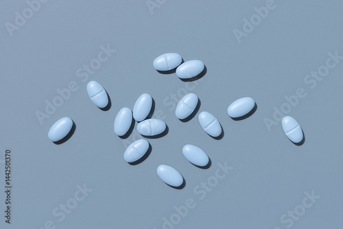 Obraz na płótnie Blue medical pills on blue top view, hard light. Pharmaceutical products for healthcare w salonie