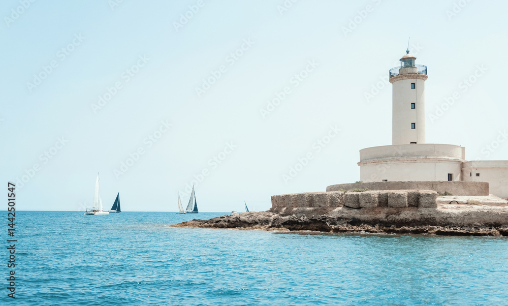 Seascape with sailboats and Brindisi lighthouse island under blue cloudless sky
