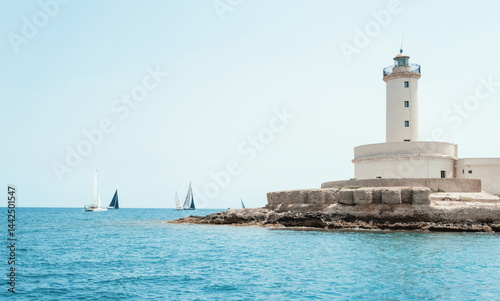 Seascape with sailboats and Brindisi lighthouse island under blue cloudless sky
