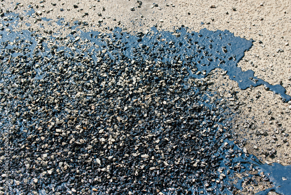 Resincoat asphalt crack repair. Road work in progress showing close view of resin coat filling cracks and asphalt patches sealing damaged street surface to prevent further pavement deterioration