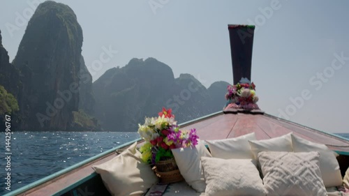 View from a luxury private longtail boat cruising around stunning Phi Phi islands, seeing the limestone cliffs rising from the turquoise water, slow motion shot.