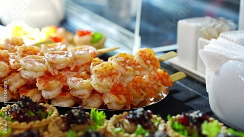 Shrimp skewers prepared for guests at a lively outdoor gathering in summer