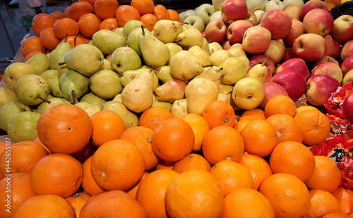 Fresh fruits, apples, oranges and pears lie on the shelf in the supermarket