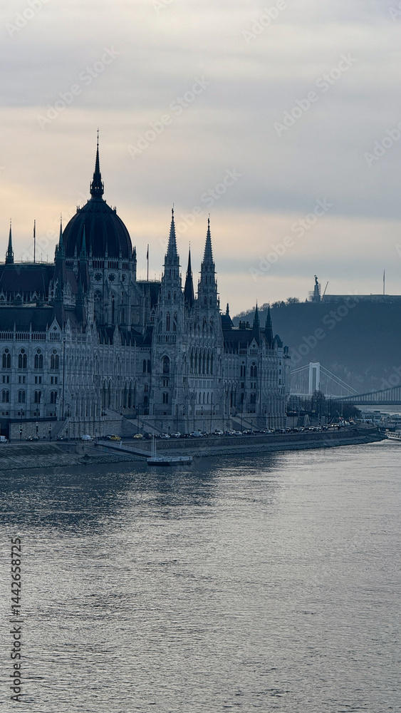 Obraz premium Gothic architecture of Budapest Parliament by the Danube River, misty dawn, travel destination, European heritage, serene landscape
