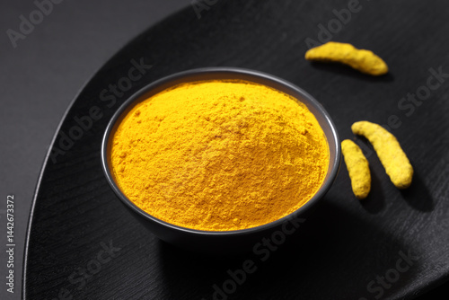 Fototapeta Naklejka Na Ścianę i Meble -  Indian spice called Turmeric Powder and roots isolated on Black Background 