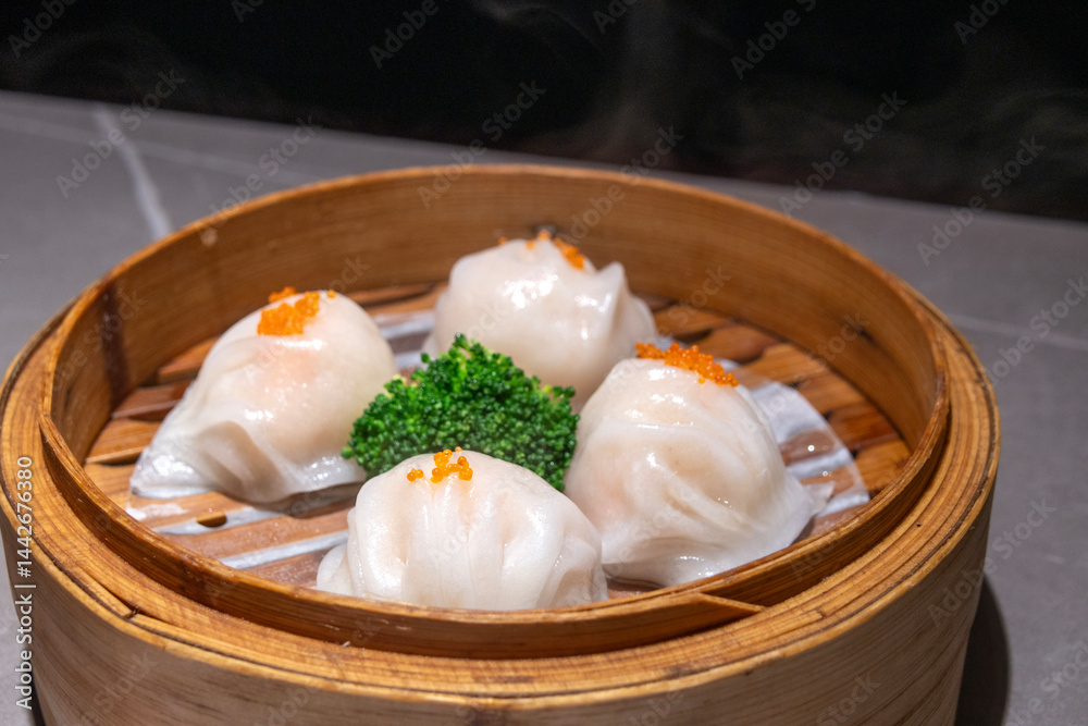 Steamed prawn dumplings, har gao, in bamboo steamers. Chinese dimsum