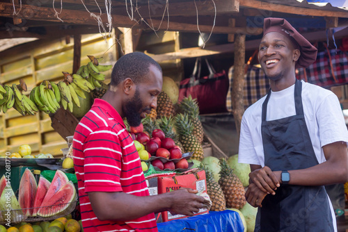 african man paying for fruits in a market