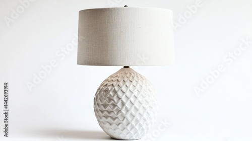White ceramic table lamp with textured surface and linen shade on white background.