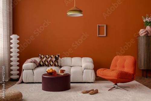 Warm modern living room with burnt orange walls, soft white sofa, and retro swivel chair. Bold colors meet cozy comfort. Stylish home decor. photo