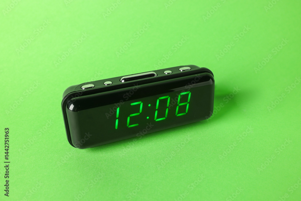Digital alarm clock showing 12:08 o'clock on green background Digital alarm clock showing 12:08 o'clock on green background