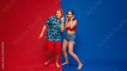 Принти на полотні Excited couple in summer outfits listening to music with exaggerated reactions and playful energy on vibrant red and blue split background