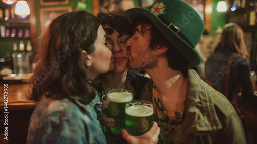 Three people celebrate with green beer, kissing in festive bar.