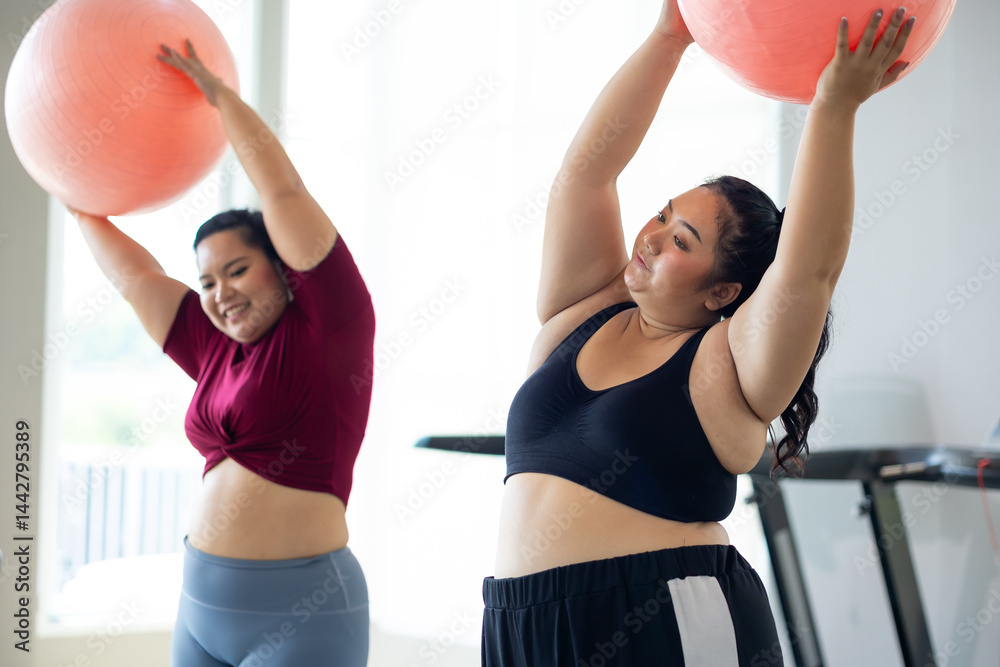 gymnastic ball. beautiful young chubby overweight woman in sportswear doing exercise indoors at gym fitness sport club, body and health care