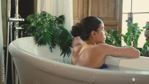 Mindfulness and relax, woman lying in bathtub, relaxing and looking at window. Happy lady enjoying solitude and beauty treatments in spa, beautiful interior of bathroom in apartment or health center