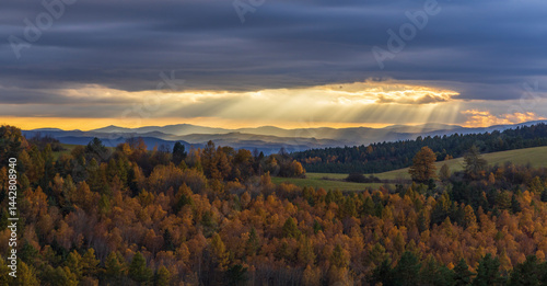 Obraz na płótnie Sun rays shining through clouds over colorful autumn forest landscape with Low Tatras w salonie