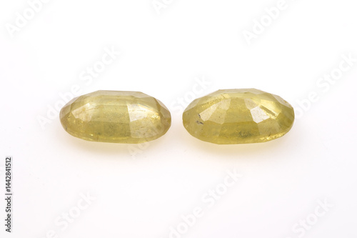 Obraz na płótnie Pair of Faceted Yellow Green Natural Sphene Gemstones Faceted Oval Shape on White Background w salonie