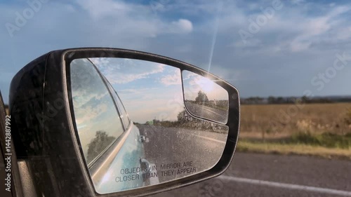 Traveling by car. Summer travel, reflection in the rear view mirror. Side mirror of a car close-up. Car mirror with reflection of the road close-up.