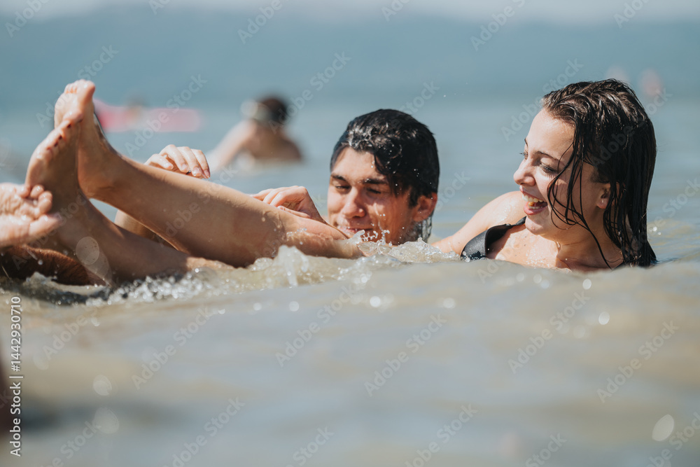 Two happy individuals playing in the water, enjoying a fun-filled summer day at the beach, capturing joy and relaxation in this lively moment.