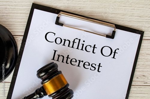 Top view of Conflict Of Interest text on clipboard with gavel on top. Conflict of interest concept