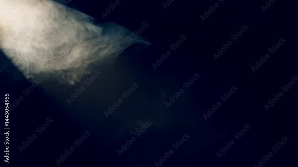 Elegant smoke clouds flowing through intense spotlight on dark abstract background video