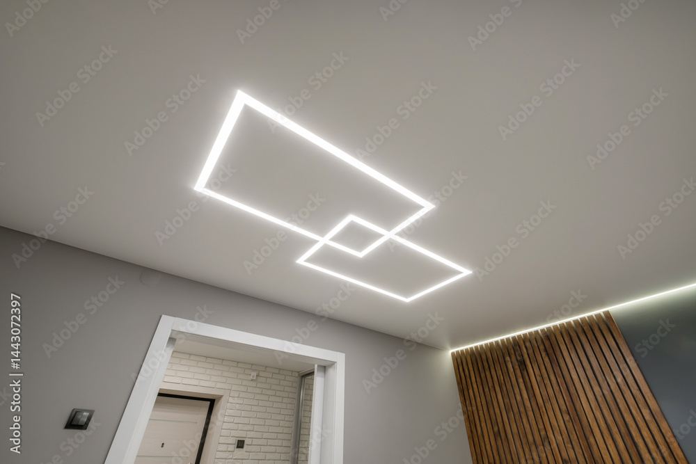 suspended ceiling with halogen spots lamps in form of squares and rectangles and drywall construction in empty room in apartment or house. Stretch ceiling white and complex shape.