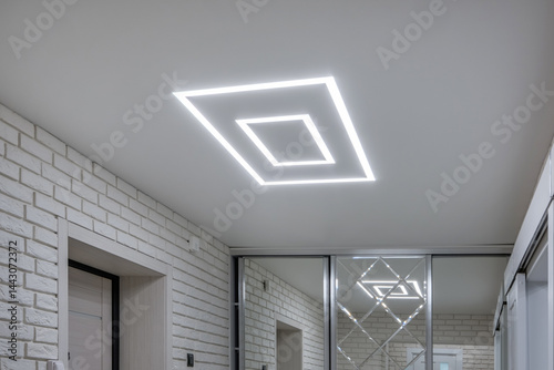 Obraz na płótnie suspended ceiling with halogen spots lamps in form of squares and rectangles and drywall construction in empty room in apartment or house. Stretch ceiling white and complex shape. w salonie